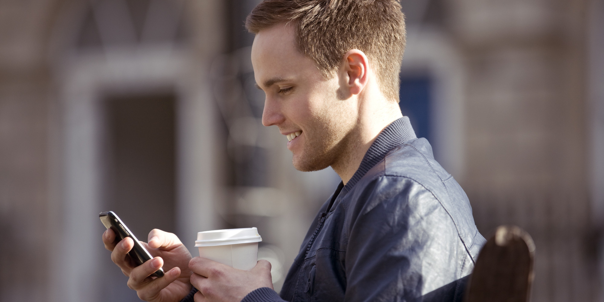 person holding phone with coffee